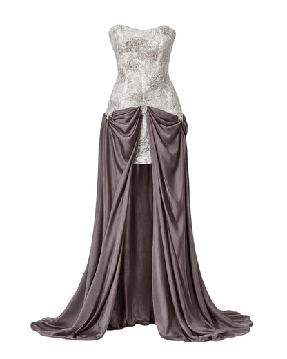 A strapless formal gown displayed on a mannequin against a plain white background. The bodice features a textured, glittering white lace overlay, while the skirt is made of draped satin in a muted  mauve color with a high draped waistline.