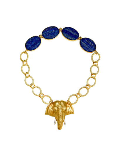A gold chain necklace featuring five oval dark blue lapis lazuli stones at the top and a textured gold elephant head pendant hanging from the center, set against a plain white background.